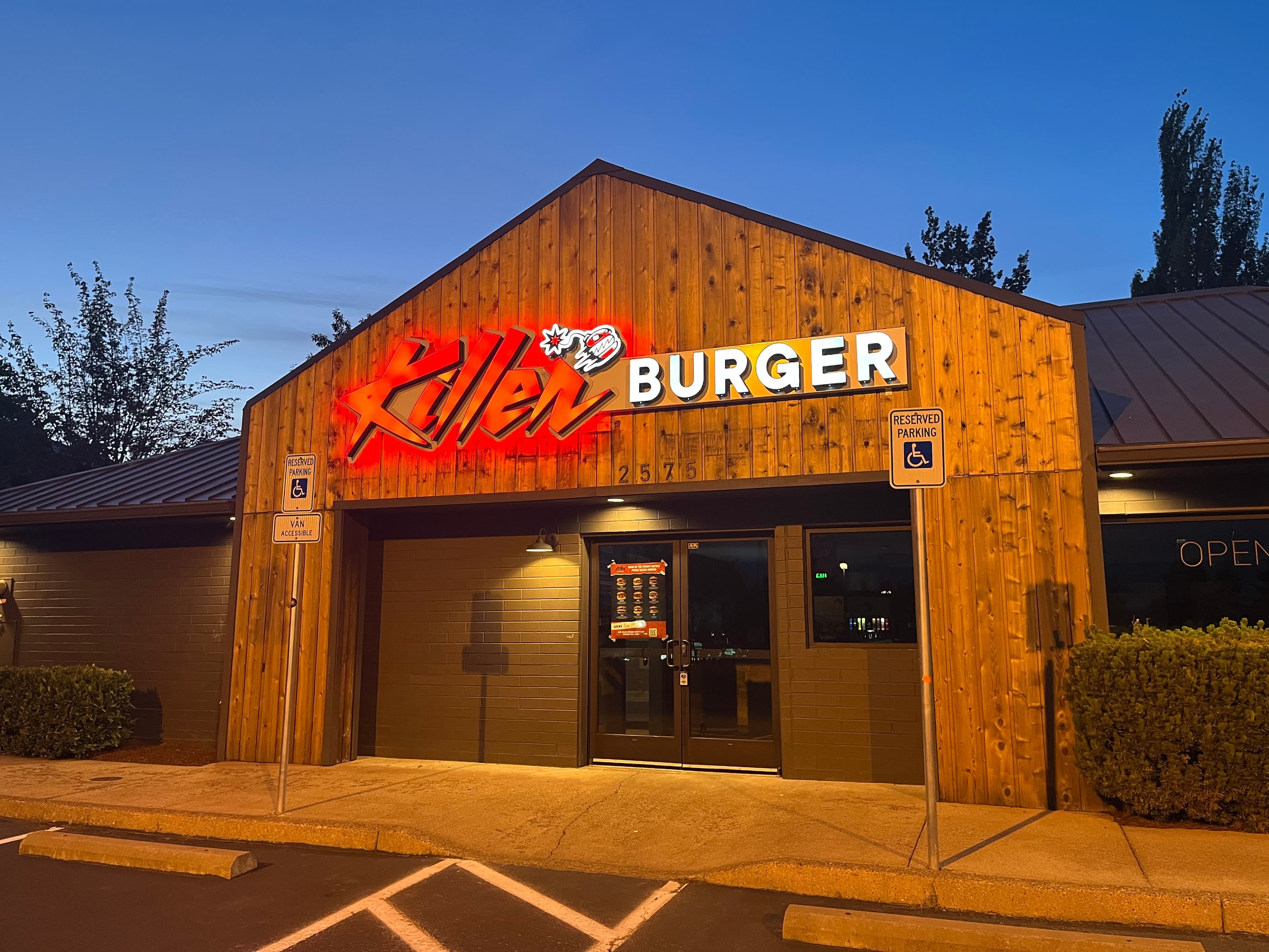 Killer Burger Corvallis — wood-sided building exterior at dusk with illuminated signage